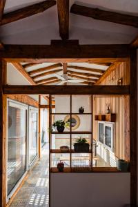 a living room with a wooden ceiling and a room with windows at EL House in Gyeongju
