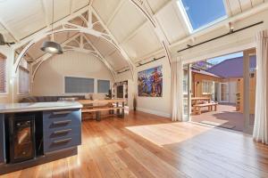 een open keuken en een woonkamer met een gewelfd plafond bij Hardy Street School House in Nelson