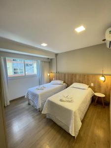ein Hotelzimmer mit 2 Betten und einem Fenster in der Unterkunft Apto. Lindo no Vita Boulevard, 500m Rua Coberta in Gramado