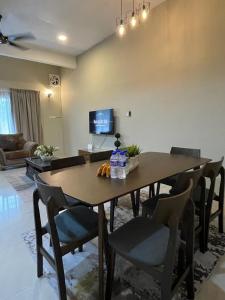 uma mesa de jantar e cadeiras numa sala de estar em Four Rooms Homstay 'A' With Wifi And Smart TV in Wakaf Tapai 