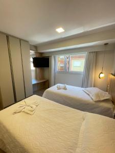 ein Hotelzimmer mit 2 Betten und einem Fenster in der Unterkunft Apto. Lindo no Vita Boulevard, 500m Rua Coberta in Gramado
