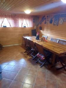 a dining room with a large wooden table and chairs at House Sumska Idila in Jasenak