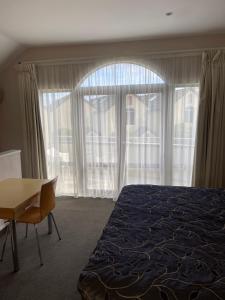 a bedroom with a bed and a desk and a window at BPS apartment 3 in Taupo