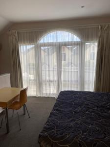 a bedroom with a bed and a desk and a window at BPS apartment 3 in Taupo +8 photos