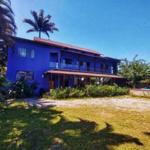 een blauw huis met een palmboom erachter bij Pousada Tropicália Paraty in Paraty