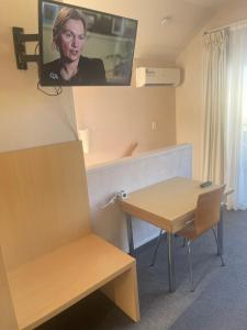 a room with a table and a tv on the wall at BPS apartment 3 in Taupo