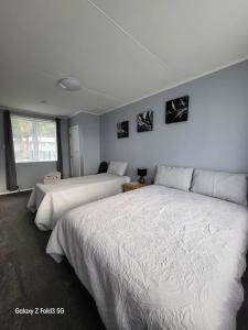2 camas en una habitación con paredes blancas en Stylish Homestay Close CBD en Hamilton