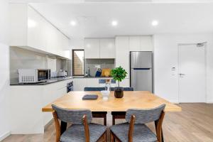 une cuisine avec une table en bois et deux chaises dans l'établissement Centre of Newtown 2 Bed Apartment, à Sydney
