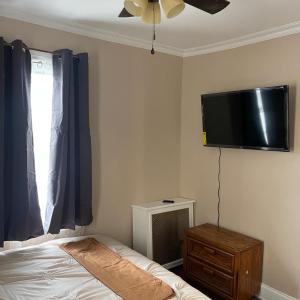 a bedroom with a bed and a flat screen tv on the wall at Don cozy in Saint Albans