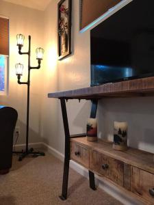 a living room with a table with a television on it at Spacious upstairs studio with kitchenette & 1 bath in Grants Pass
