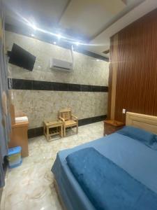 1 dormitorio con 1 cama y TV en la pared en Khách Sạn Hội Nghĩa Bình Dương en Hoi Nghia