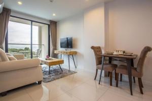 a living room with a couch and a table and a tv at Bangsaray Vacation in Bang Sare