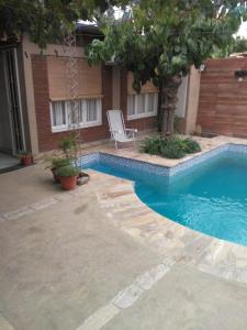 una piscina con una silla junto a una casa en Alquiler para turistas en San Rafael