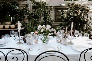 a white table with glasses and flowers on it at Jacks Garden Cottage at Poets Lodge in Daylesford