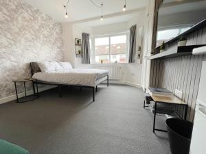Un dormitorio con una cama y una mesa. en Cosy Bright Studio Apartment Close to Wembley Stadium en Londres