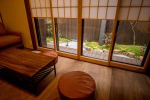 a living room with two large windows with a garden outside at RESI STAY Villa Silktree in Kyoto