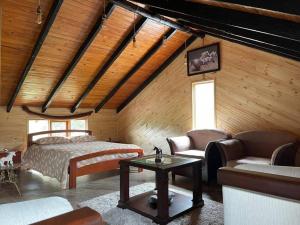 1 dormitorio con cama, sofá y mesa en Acogedora Cabaña Chalet en Medio de la Naturaleza, en Aquitania