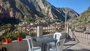 einen Tisch und Stühle auf einem Balkon mit Bergblick in der Unterkunft Hospedaje Ale in Iruya