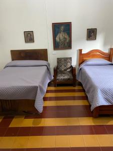 um quarto com duas camas e uma cadeira em Vivienda Turística - Casa de Carola em Jardín
