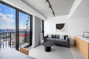 a living room with a couch and a large window at Nesuto Docklands in Melbourne