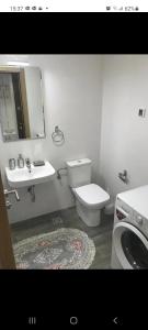 a bathroom with a toilet and a sink and a mirror at KENZA jednosobni stanovi in Podgorica +16 photos