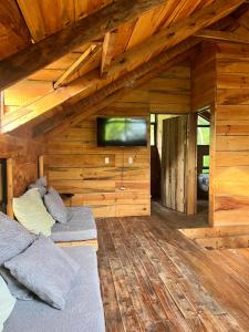 a living room with a couch and a flat screen tv at Cabaña Trojas Valverde Vega in Trojas