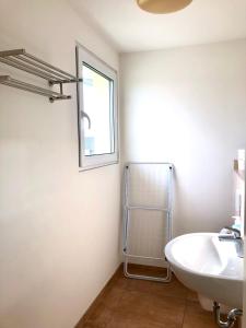 La salle de bains blanche est pourvue d'un lavabo et d'une fenêtre. dans l'établissement Pension Chen, 2 Doppelzimmer , EBK, separater Balkon, à Griesstätt