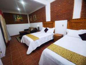 een hotelkamer met 2 bedden en een bank bij Hotel Boutique Casona Mashei in Tasquillo