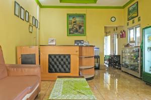 a living room with a couch and a fireplace at OYO 92486 Hotel Permata 3 in Salatiga