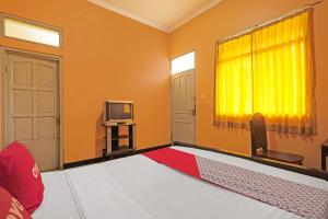 a living room with a television and a red rug at OYO 92486 Hotel Permata 3 in Salatiga