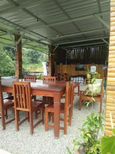 een houten tafel en stoelen onder een parasol bij Rago's Homestay in Kelimutu