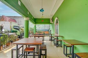 ein Restaurant mit grünen Wänden, Holztischen und Stühlen in der Unterkunft OYO 92501 Wisma Sakinah Syariah in Rambah