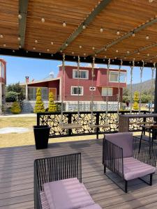 a patio with two chairs and a table on a deck at Floresta Casa de Campo in Amecameca de Juárez