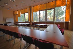 uma grande sala de conferências com uma grande mesa e cadeiras em Hotel Dainava em Druskininkai
