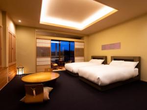 Ryotei Jyusouya في Sango: غرفة فندقية بسريرين وطاولة