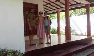 a group of three people standing on a porch at Hemamala Bungalow in Anuradhapura