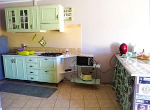 a kitchen with green cabinets and a stove top oven at B&B Maison Villa Vittorio in Avella