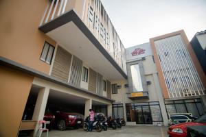 a person standing in front of a building with motorcycles at DLT Suites Boutique Hotel in Minglanilla