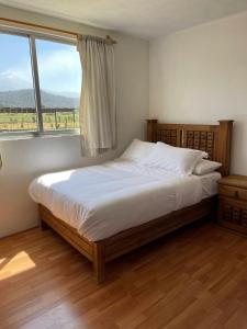 um quarto com uma cama grande e uma janela em Floresta Casa de Campo em Amecameca de Juárez