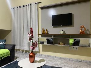 a living room with a tv on a wall at Apartamento em frente Basílica in Aparecida