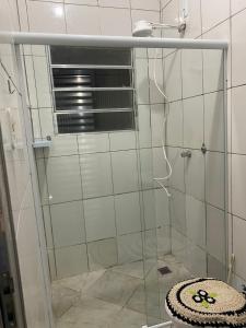 ein Bad mit einer Glasdusche und einem WC in der Unterkunft Apartamento em frente Basílica in Aparecida