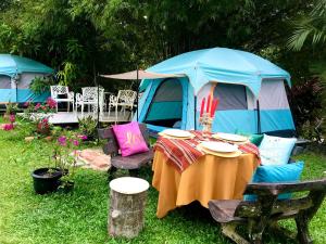 Eco Resort Beverly Hills في ايبوه: خيمة امامها طاولة وكراسي