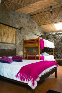 1 dormitorio con 1 cama grande con mantas rosas en Termales SironaSpa, en Gama