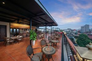 ein Restaurant mit Tischen und Stühlen auf einem Balkon in der Unterkunft MK Premier Boutique Hotel in Hanoi