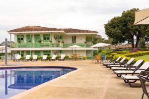 a villa with a swimming pool and chairs at Hotel Eden Parque del Cafe in Montenegro