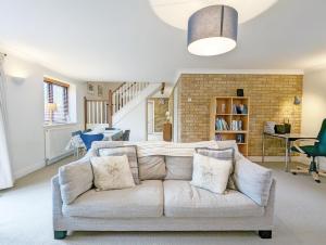 a living room with a couch and a brick wall at Old Lock Cottage, Birdham in Birdham