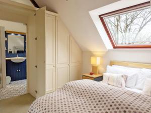 a bedroom with a bed and a window and a sink at Old Lock Cottage, Birdham in Birdham