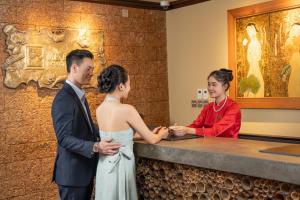 a bride and groom standing at a bar at their wedding reception at MK Premier Boutique Hotel in Hanoi