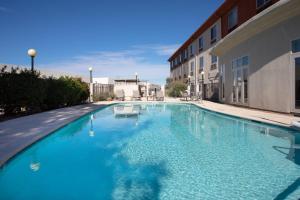 a large blue swimming pool next to a building at Holiday Inn Express & Suites Tucson, an IHG Hotel in Tucson