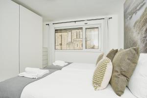 Un dormitorio blanco con una cama grande y una ventana en Sundowners, en Ryde